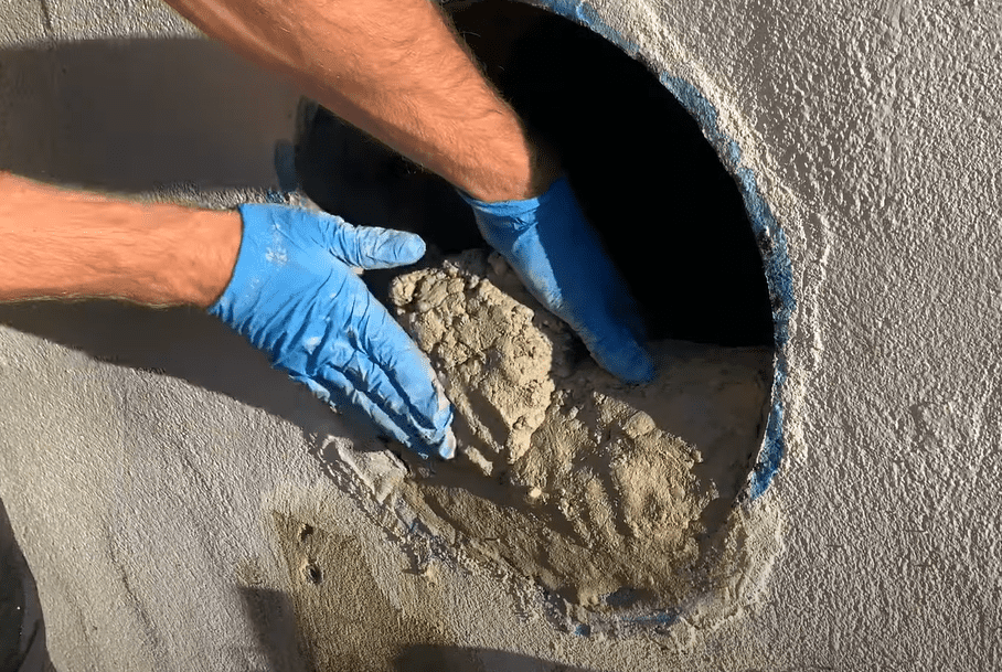 Apply concrete to patch hole in concrete foundation