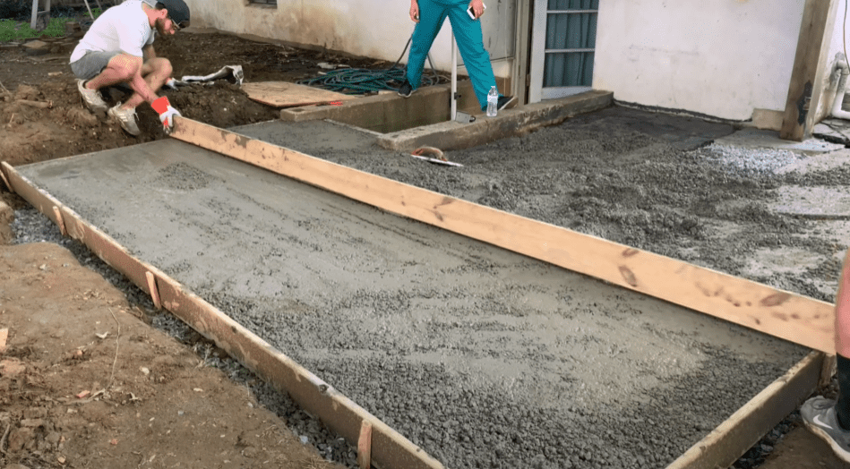 Use a board to screed the surface of your concrete slab extension