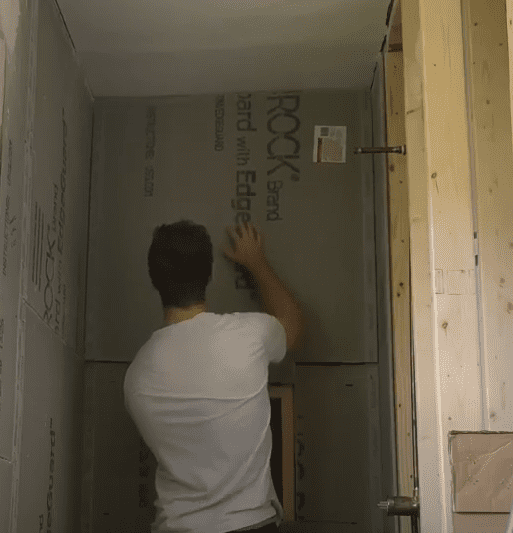 Positioning Cement Board on Wall Before Securing it with Screws