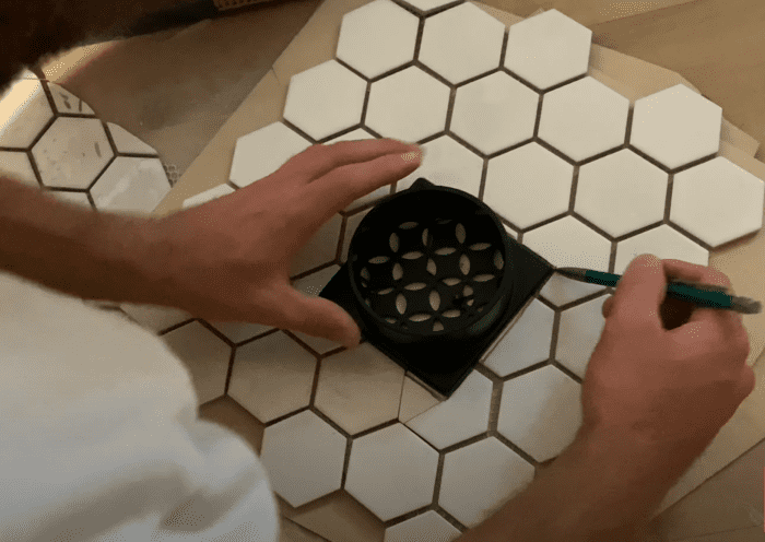 Trace the outline of your shower drain on the face of the tiles