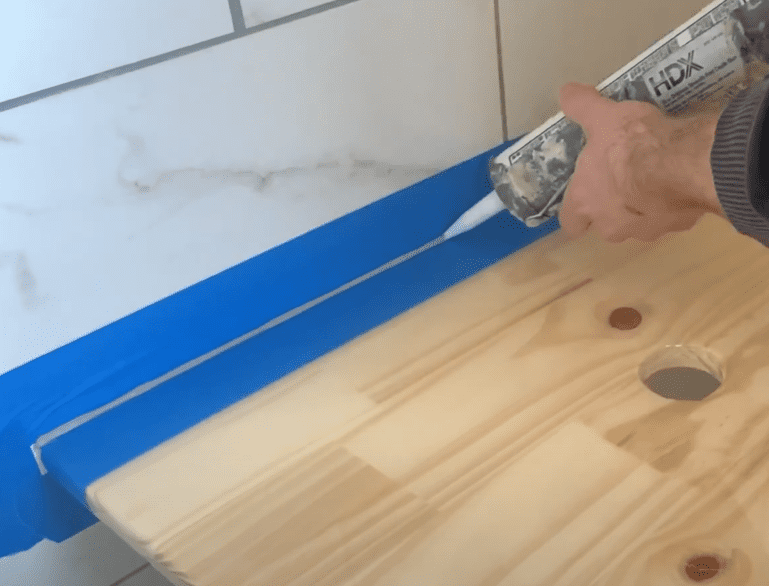 Caulk the seam between the floating vanity and the wall