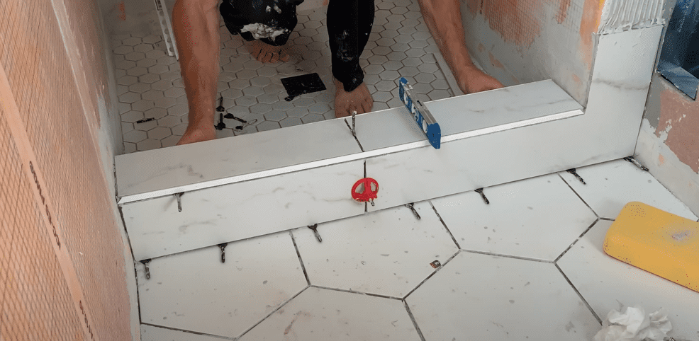 Ensure that water on the top of the shower curb will drain back into the shower pan