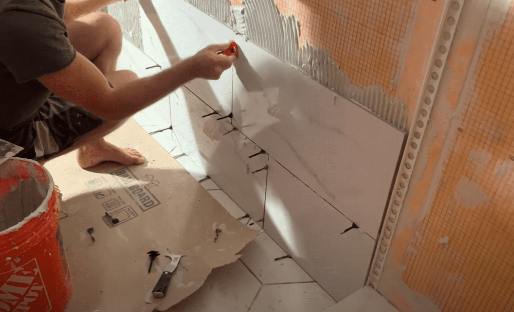 Apply the second row of bathroom wall tiles and install the tiling leveling system