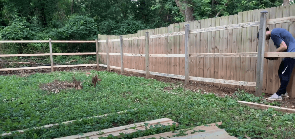 Continue to install your horizontal fence rails along the bottom, center, and top of your fence. 