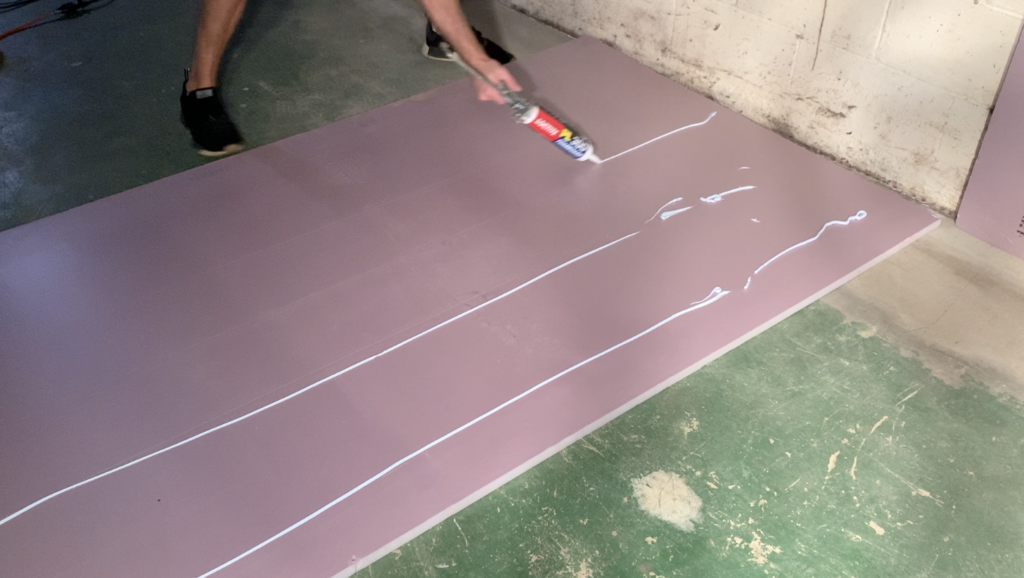 Apply beads of adhesive to the back of the rigid foam board insulation
