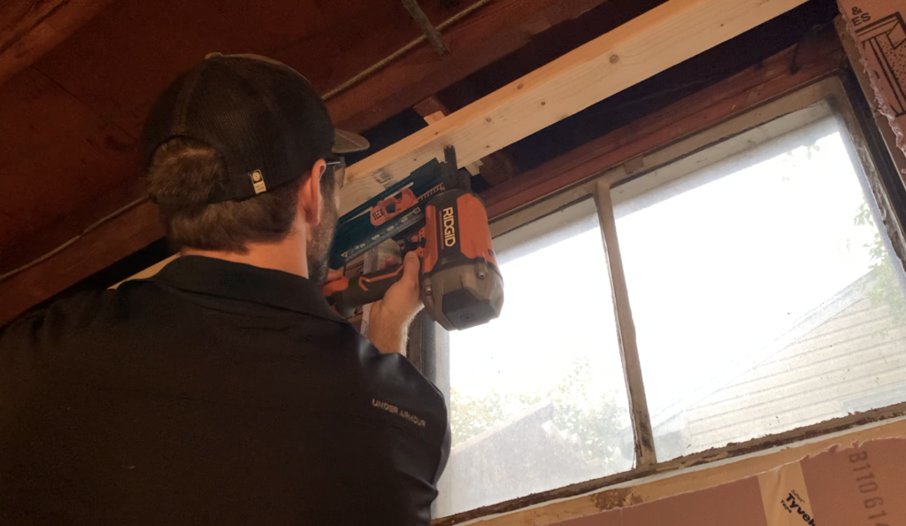 Attach the top plate to the floor joists above using a framing nailer