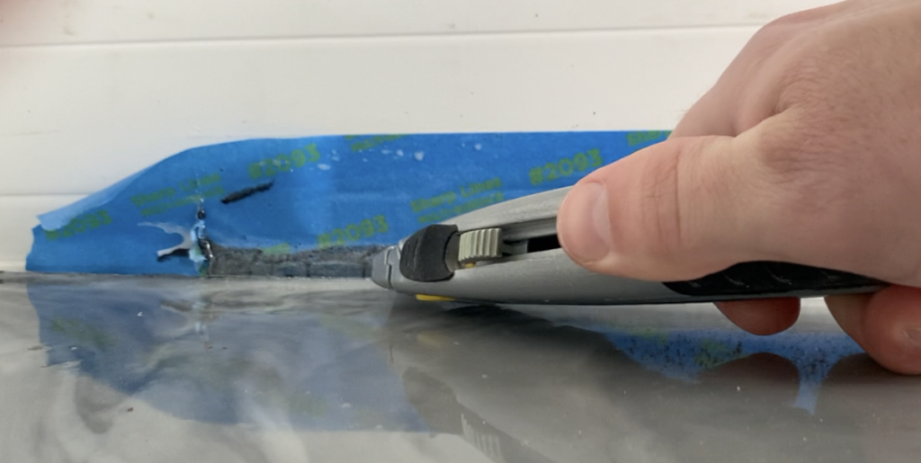 Use a utility knife to score the painter's tape along the floor/wall intersection 
