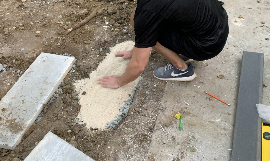 Spread the sand layer over the stone sub-base so that it is uniform