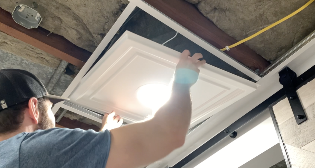 Lift the drop ceiling panel (with the recessed light installed) into place within the grid