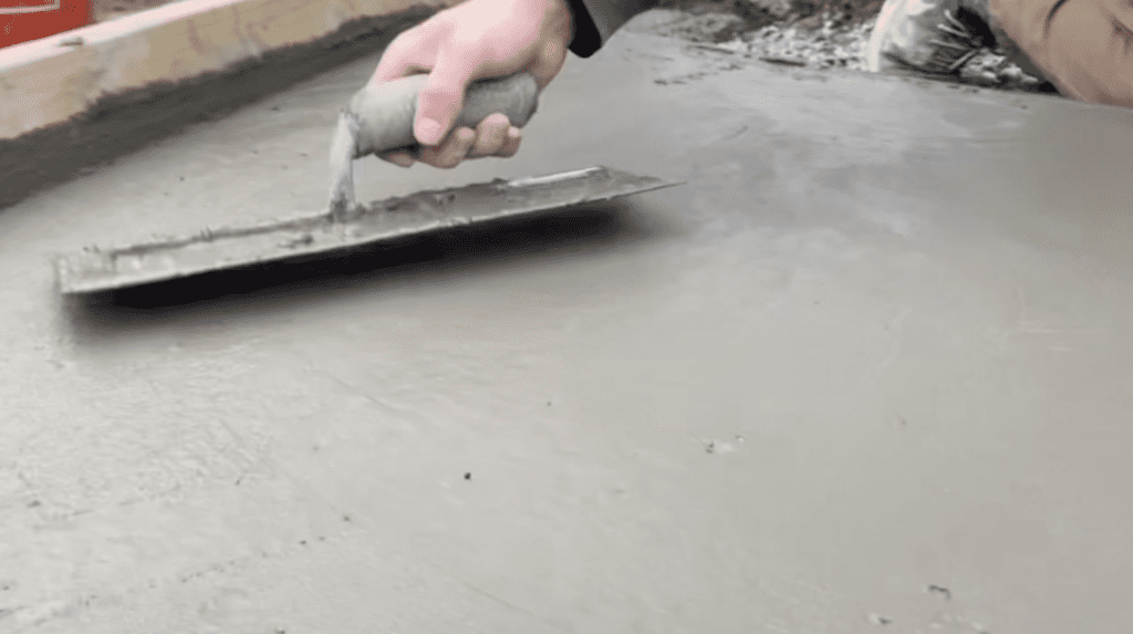 Smooth out the surface of the concrete using a hand trowel