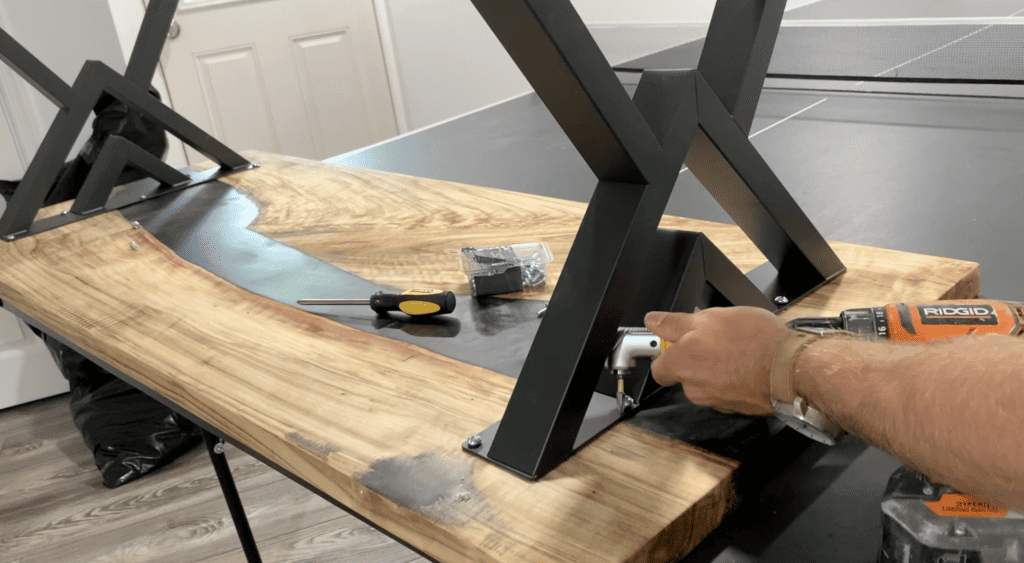 Bolt the table legs to the epoxy river table using a screwdriver or a drill
