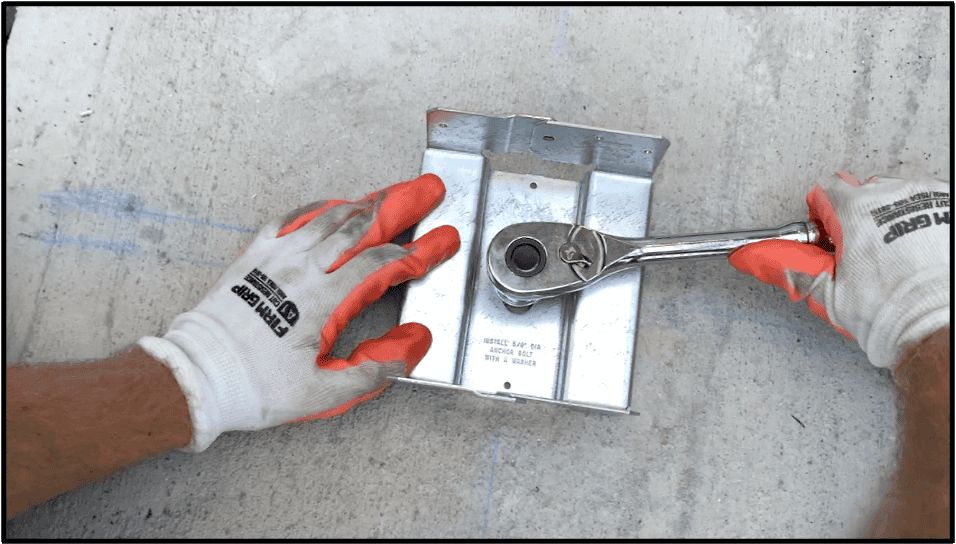 Secure the post anchor to the concrete slab using a socket wrench